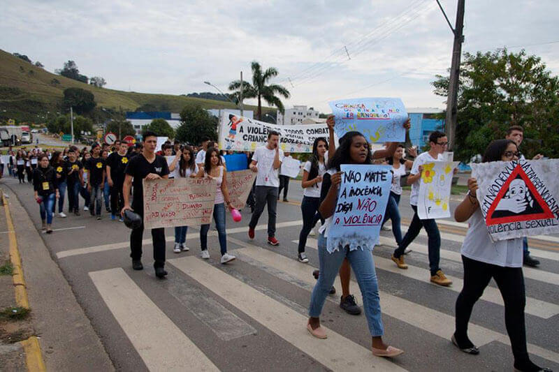 Jovens protentando em via pública com cartazes contra a violência