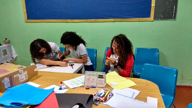 Meninas fazendo trabalho escolar em sala